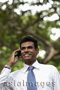 Asia Images Group - Portrait of Indian man talking on phone and smiling outdoors