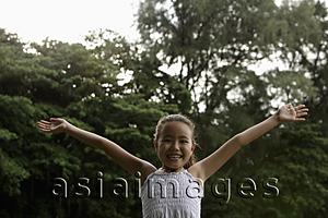 Asia Images Group - young girl with ams outstretched smiling at camera
