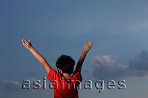 Asia Images Group - back view of young boy with red shirt with arms outstretched