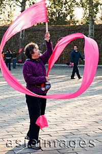 Asia Images Group - China,Beijing,Summer Palace Park,Woman Exercising with pink ribbon