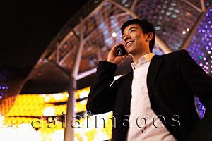 Asia Images Group - young man talking on phone smiling at night