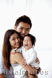 Asia Images Group - Mother and father holding crying baby