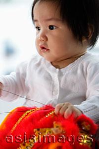 Asia Images Group - Chinese baby holding red toy
