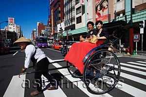 Asia Images Group - Couple in Rickshaw crossing the street.  Japan,Tokyo,Asakusa,