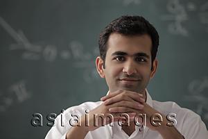 Asia Images Group - Head shot of young man with hands folded.