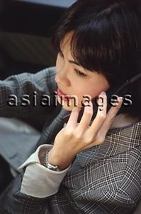 Asia Images Group - Female executive talking on cellular phone in car