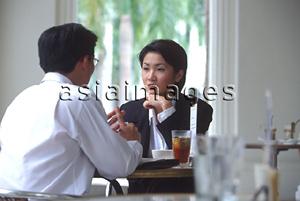 Asia Images Group - Two executives talking in cafe