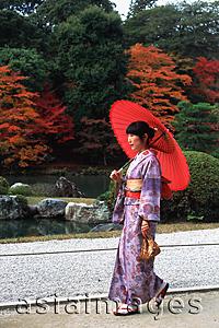 Asia Images Group - Japan, woman in kimono walking in temple garden with red umbrella