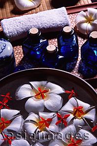 Asia Images Group - Still life with bowl, floating fresh flowers and blue glass bottles