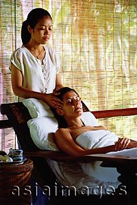 Asia Images Group - Caucasian female receiving a head massage from Asian masseuse
