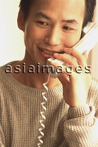 Asia Images Group - Man talking on telephone, smiling