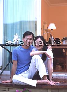 Asia Images Group - Couple sitting outdoors on balcony