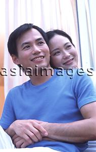 Asia Images Group - Couple embracing, sitting outdoors