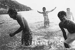 Asia Images Group - Teenagers splashing in the ocean