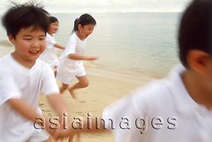 Asia Images Group - Children in white outfits running along the beach