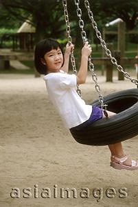 Asia Images Group - Girl playing on swing