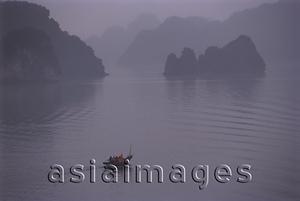 Asia Images Group - Vietnam, Halong Bay, lone fishing boat in the mist.