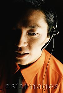 Asia Images Group - Male executive using telephone headset, portrait
