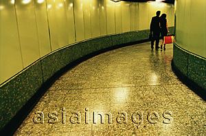 Asia Images Group - Hong Kong, man and woman walking in MTR (subway) station