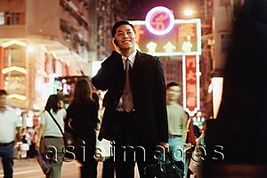 Asia Images Group - Hong Kong, male executive using cellular phone, carrying briefcase