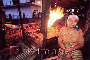 Asia Images Group - Indonesia, Sumatra, Aceh, Acehnese woman selling grilled meat at Sunset Beach.