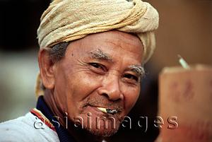 Asia Images Group - Malaysia, Kota Bahru, A Malay Muslim fisherman smokes a hand-rolled cigarette.