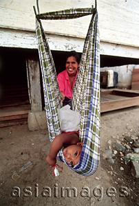 Asia Images Group - Indonesia, Aceh, Banda Aceh, Mother cares for child in makeshift swing.