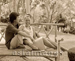 Asia Images Group - Man talking with woman on bench outdoors