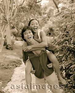 Asia Images Group - Man carrying woman on back, laughing