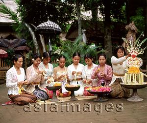 Asia Images Group - Indonesia, Bali, Balinese women and girls in traditional costume making floral arrangements