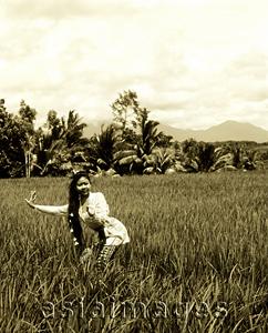 Asia Images Group - Indonesia, Bali, Balinese dancer in fields, trees in background