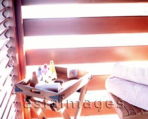 Asia Images Group - Multi-colored bottles and small clock sit on wooden tray in corner of room