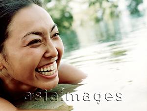 Asia Images Group - Woman in water, smiling.