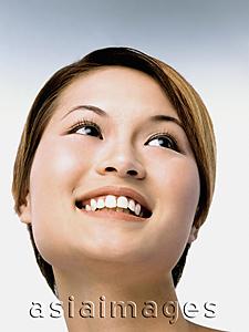 Asia Images Group - Young woman smiling, portrait, low angle view