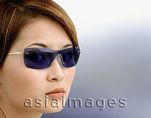 Asia Images Group - Young woman wearing blue tinted sunglasses, portrait