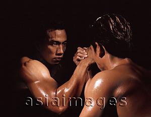 Asia Images Group - Two men arm wrestling, black background