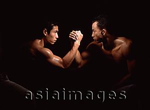 Asia Images Group - Two men arm wrestling, black background