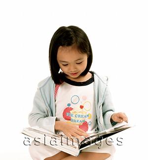 Asia Images Group - Young girl reading book, white background.