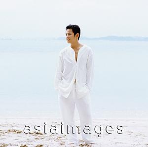 Asia Images Group - Young man standing on beach