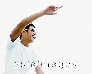 Asia Images Group - Young man wearing sunglasses, pointing, smiling, white background