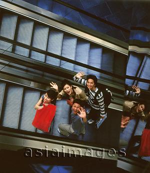 Asia Images Group - Group of friends carrying shopping bag on escalator.