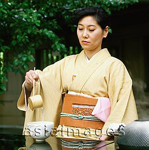 Asia Images Group - Japan, Woman in kimono performing outdoor tea ceremony