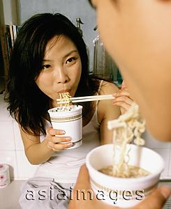Asia Images Group - Couple eating instant noodles