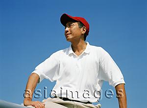 Asia Images Group - Mature man with red cap, outdoors, looking off camera