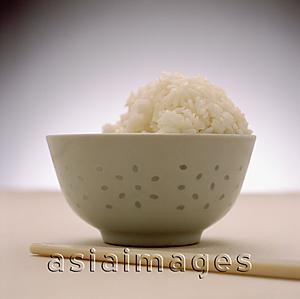 Asia Images Group - Half-eaten bowl of rice with chopsticks in foreground