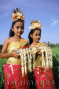 Asia Images Group - Indonesia, Bali, Young Balinese dancers in costume with offerings in rice paddy.