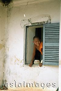 Asia Images Group - Laos, Luang Prabang, Young monk looking out of window at monastery