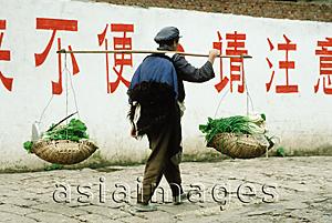 Asia Images Group - China, Lijiang, Naxi man carrying baskets of vegetables