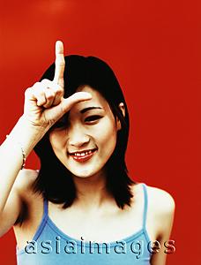 Asia Images Group - Young woman with finger and thumb in shape of 