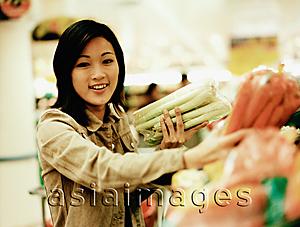 Asia Images Group - Young woman shopping for produce, portrait.
